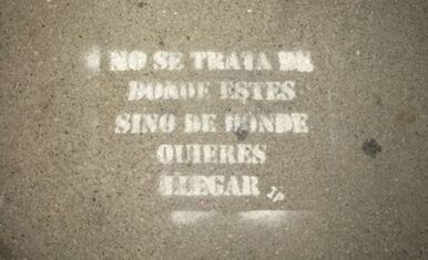 Quote on sidewalk says, “No se trata de donde estés sino de donde quieres llegar.” It does not matter where you start, just where you want to be.